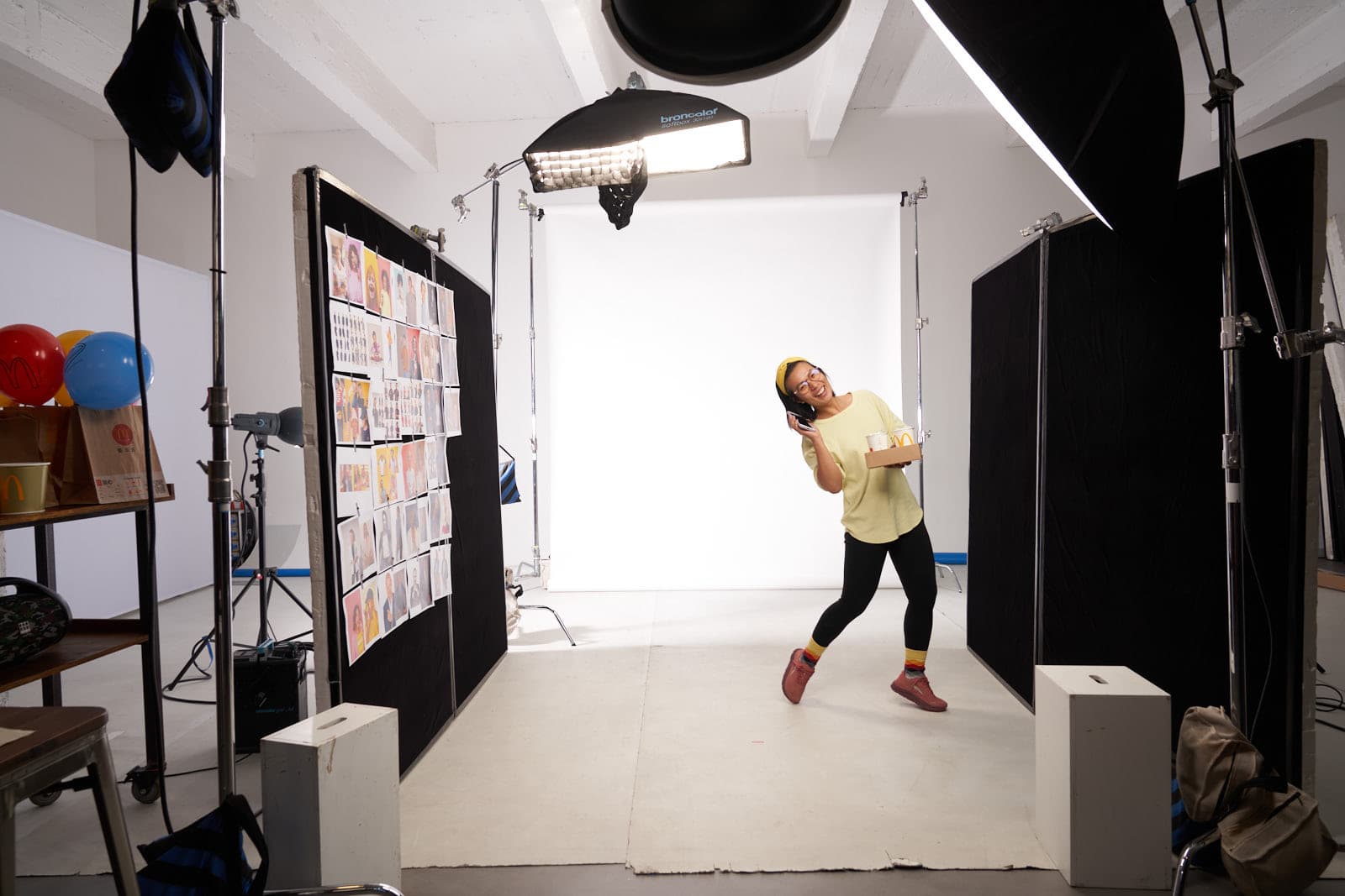 Behind the scenes of commercial studio shoot with model on white backdrop and mood board by Una Zhu