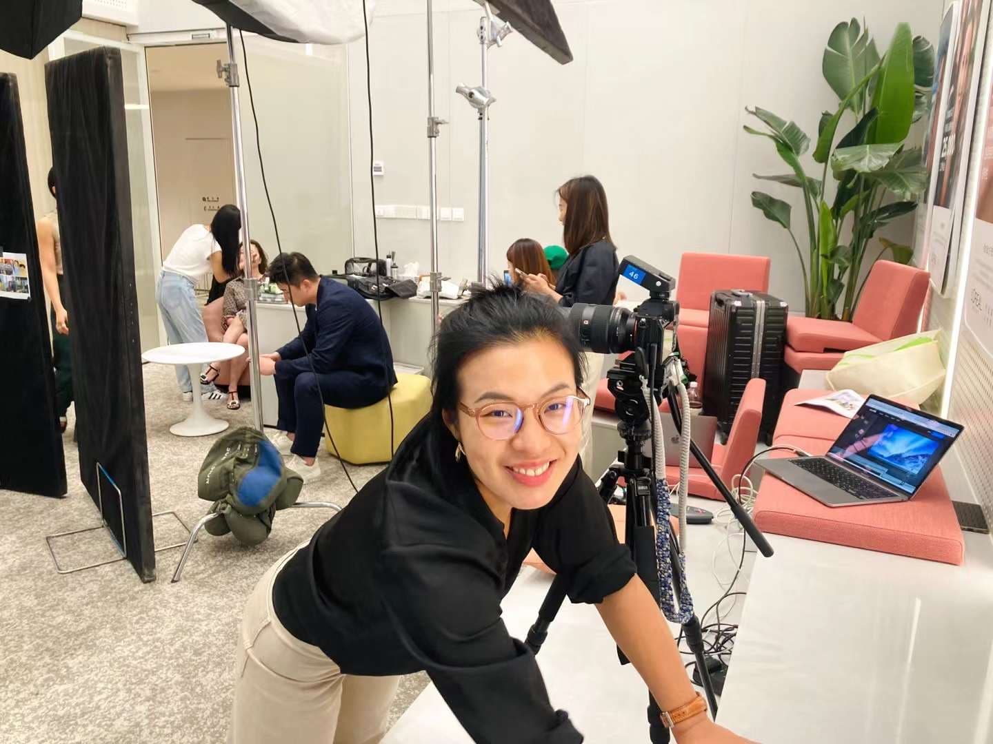 Behind the scenes of Una Zhu setting up camera on set with crew and styling team in studio