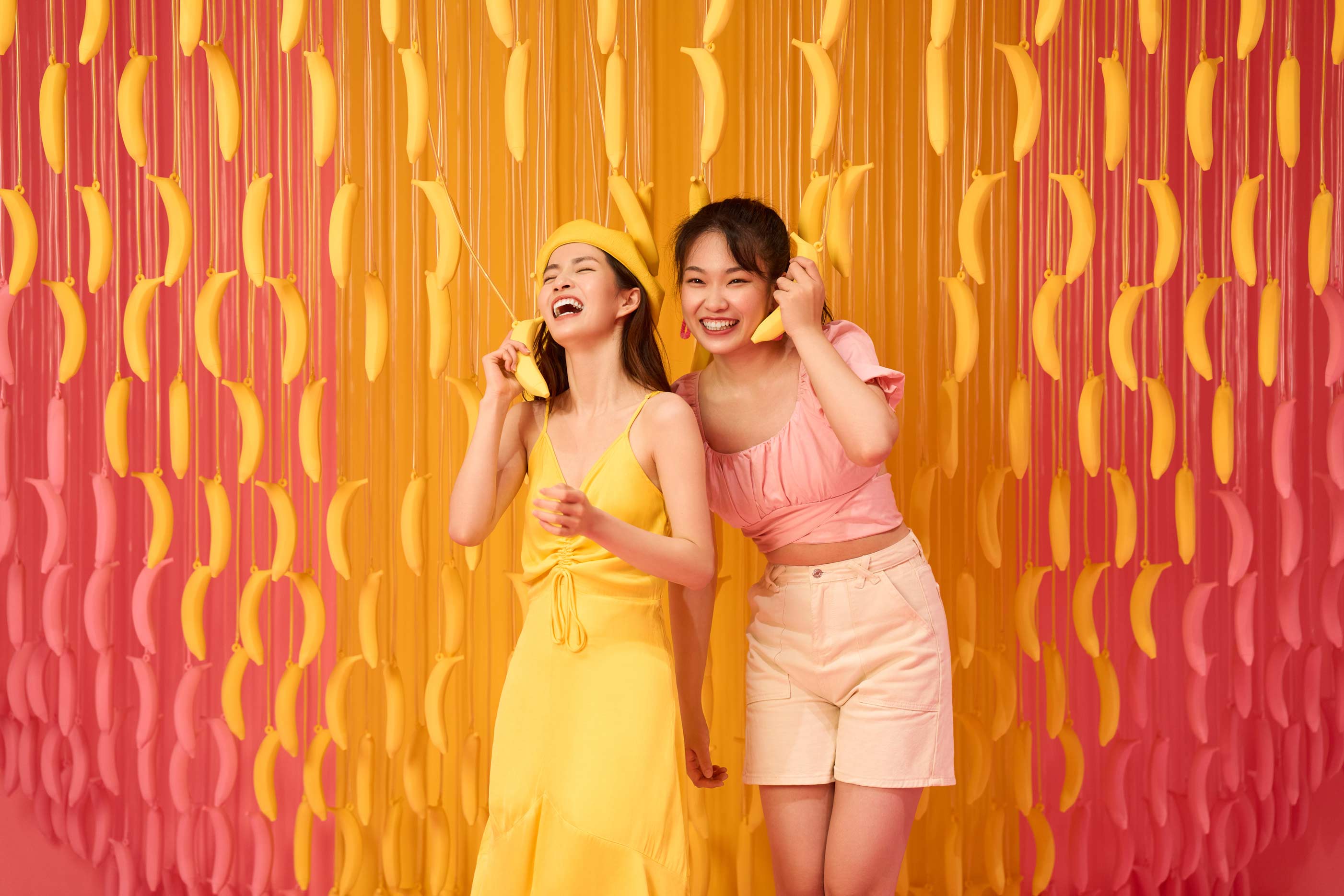 Lifestyle brand campaign with two women laughing at colorful pop-up installation by Una Zhu